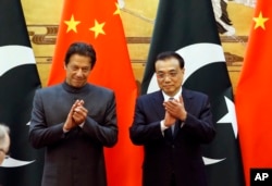 Pakistani Prime Minister Imran Khan, left, and China's Premier Li Keqiang attend a signing ceremony at the Great Hall of the People in Beijing, Nov. 3, 2018.
