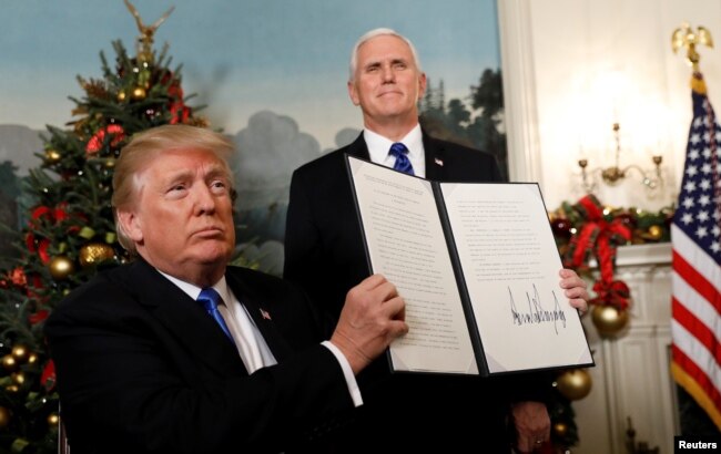 FILE - After signing, U.S. President Donald Trump holds up the proclamation that the United States recognizes Jerusalem as the capital of Israel and will move its embassy there, during an address from the White House in Washington, U.S., Dec. 6, 2017.