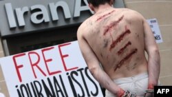 FILE - Reporters Without Borders activists take part in a protest in front of an Iran Air agency in Paris, on July 10, 2012.