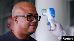Dr. Chikwe Ihekweazu, the Director General of the Nigeria Centre for Disease Control (NCDC) has his temperature checked during a diplomatic meeting at the Ministry of Foreign Affairs in Abuja, Nigeria on March 12, 2020. 