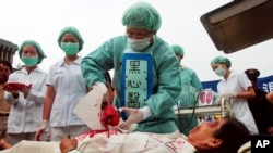 Falun Gong practitioners pretend to harvest organ in a mock, or fake, Chinese labor camp. They protested in front of the Presidential Office in Taipei, Taiwan for China's suspected killing of Falun Gong members in prison for their organs. (2006)