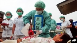 FILE – Falun Gong practitioners simulate organ harvesting in a mock Chinese labor camp in front of the Presidential Office in Taipei, Taiwan, April 23, 2006, in protest against China's suspected abuse and killing of Falun Gong members. 