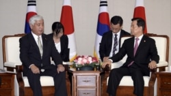 South Korean Defense Minister Han Min-Koo (R) talks with Japanese Defence Minister Gen Nakatani