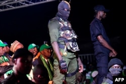 FILE - Security agents stand guard during the campaign meeting of Issa Sall, presidential candidate and deputy president of the Senegalese "Parti de l'Unite et du Rassemblement" (PUR), at the municipal stadium of Thiaroye, a suburb of Dakar, Feb. 3, 2019.