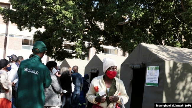 A woman holds her vaccination card after getting a second shot at a government hospital in Harare, Zimbabwe on Monday, Sept, 13, 2021. (AP Photo/Tsvangirayi Mukwazhi)