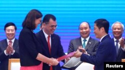 European Commissioner for Trade Cecilia Malmstrom, Romania's Business, Trade and Enterpreneurship Minister Stefan Radu Oprea and Vietnam's Industry and Trade Minister Tran Tuan Anh exchange documents while attending the signing ceremony of EU-Vietnam Free