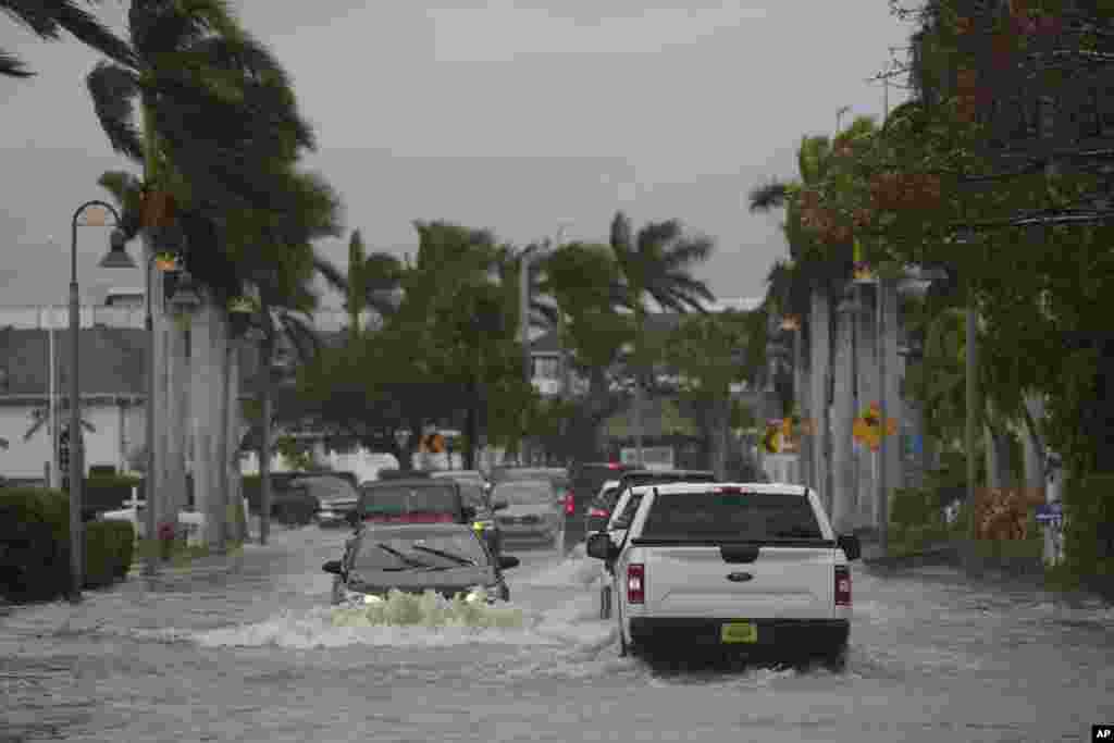 Los conductores navegan por una calle inundada tras el paso del huracán Nicole, en Fort Pierce, Florida.