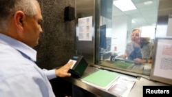 A man has his fingerprints electronically taken while taking part in a visa application demonstration