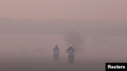 Arhiva - Motociklisti se probijaju kroz smog u Nju Delhiju, Indija, 13. oktobra 2017. 