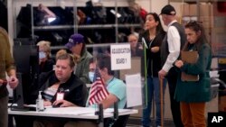 Election adjudicators and observers watch ballot tabulation inside the Maricopa County Recorders Office in Phoenix, Arizona, Nov. 10, 2022.