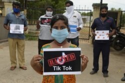 Members of the City Youth Organization hold posters with the logos of Chinese apps in support of the Indian government for banning the popular video-sharing 'TikTok' app, in Hyderabad on June 30, 2020.