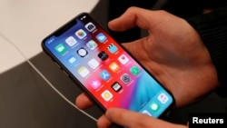 FILE - A customer tests an iPhone at a shop in Moscow, Russia, September 28, 2018. 