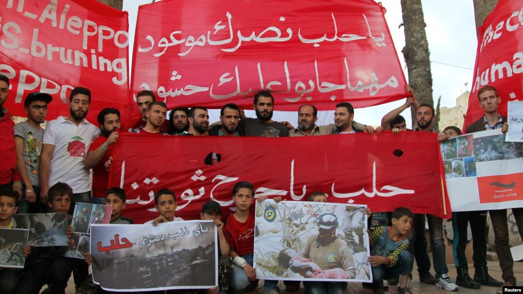 People hold banners during a sit-in in solidarity with the people of Aleppo in Idlib, Syria, May 4, 2016. The banner reads: "Oh, Aleppo, your victory is promised no matter how many crowds they bring to you."