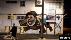 Israeli graffiti artist Liron Tapiro carries his ladder after he finished a graffiti of Hezbollah leader Sayyed Hassan Nasrallah after Israel's military confirmed it had killed him in a Beirut airstrike, in Tel Aviv, Israel, Sept. 29, 2024. 