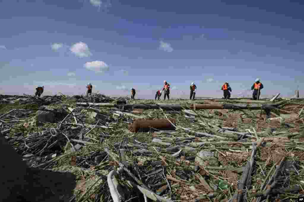 Police officers search for the remains of those who went missing in the March 11, 2011 tsunami on the coastline in Ishinomaki, Miyagi Prefecture, northern Japan, March 11, 2013.