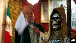 In this Feb. 19, 2017 photo, a statue of the Death Saint stands inside Mercy Church as Juan Carlos Avila Mercado gives a service, on the edge of Mexico City's Tepito neighborhood.