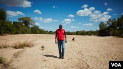International Federation of Red Cross and Red Crescent Societies Secretary General Elhaji As Sy walks a sandy riverbed of Mudzi River in Zimbabwe as a drought grips the southern African region, May 15, 2016. Locals say that, at this time of year, the river would normally be at least one meter deep. Photo: (S. Mhofu/VOA)