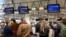 People wait to check in to a flight to Chicago at the United Airlines counter in the main terminal of Brussels International Airport in Brussels, March 12, 2020. 