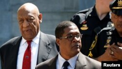 Actor and comedian Bill Cosby, left, exits Montgomery County Courthouse after a jury convicted him in a sexual assault retrial in Norristown, Pennsylvania, April 26, 2018. 