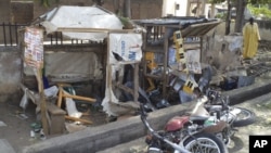 A man inspects the wreckage following a suicide bomb attack on a street in Jalingo, Nigeria, April 30, 2012.