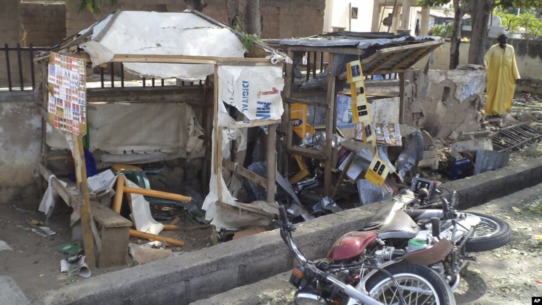 A man inspects the wreckage following a suicide bomb attack on a street in Jalingo, Nigeria, April 30, 2012.