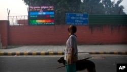 An Indian looks at the air quality level board outside India Meteorological Department, which shows condition of air as severe post during Diwali festival, in New Delhi, Oct. 20, 2017.