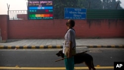 An Indian looks at the air quality level board outside India Meteorological Department, which shows condition of air as severe post during Diwali festival, in New Delhi, Oct. 20, 2017.