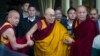 The Dalai Lama, in yellow robe, is helped by attending monks as he leaves after a religious talk at the Tsuglakhang temple in Dharmsala, India, March 14, 2017.