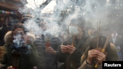 People burn incense sticks and pray for good fortune at Yonghegong Lama Temple on the first day of the Lunar New Year of the Pig in Beijing, China, Feb. 5, 2019. 