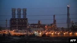 资料照片: 2019年12月11日沙特阿拉伯东部省份达曼以北朱拜勒工业城的一家炼油厂夜景