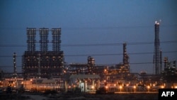 FILE - A refinery is lit up at the Jubail Industrial City, about 95 kilometers north of Dammam, in Saudi Arabia's eastern province overlooking the Gulf, Dec. 11, 2019.
