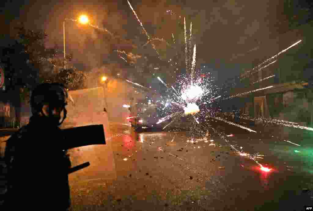 Supporters of Lebanon&#39;s Shi&#39;ite Hezbollah and Amal groups throw fireworks at security forces in central Beirut.