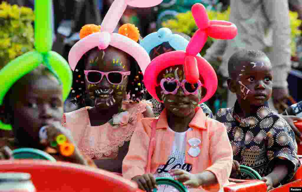 Children ride on a makeshift funfair train at the Uhuru Park grounds during Christmas Day celebrations in Nairobi, Kenya.