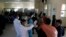 FILE - Afghan health workers measure the temperature of Afghan refugees to screen for coronavirus as they enter Afghanistan at the Islam Qala border crossing with Iran, in the western Herat Province, March 18, 2020.