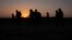 FILE - The sun rises as asylum-seeking migrant families from Honduras and El Salvador walk toward the border wall after crossing the Rio Grande into the United States from Mexico on a raft in Penitas, Texas, on March 26, 2021. 