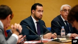 Former President Emmanuel Macron's security aide Alexandre Benalla, center, appears before the French Senate Laws Commission prior to his hearing, in Paris, Sept. 19, 2018.