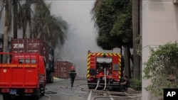 A firefighter runs as Taiwanese bicycle factory Tan Than Industries burns in Di An Town, Binh Duong province, Wednesday, May 14, 2014