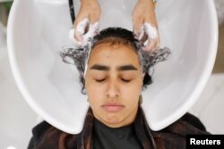 Palestinian-American Raneem Ayesh, 16, has her hair washed at the Le'Jemalik Salon and Boutique ahead of the Eid al-Fitr Islamic holiday in Brooklyn, New York, June 21, 2017.