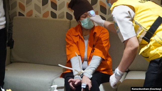 Maria Pauline Lumowa, buron kasus pembobolan BNI yang baru saja diekstradisi dari Serbia, diperiksa suhu tubunya saat tiba di Bandara Soekarno-Hatta, Kamis, 9 Juli 2020. (Foto: Kemenkumham)
