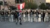 Un hombre sostiene una bandera nacional frente a los policías durante una protesta contra el gobierno del presidente de Perú, Pedro Castillo, en Lima, la capital, el 5 de noviembre de 2022.