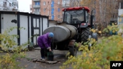 A local resident collects water from a tank in Stepnogirsk on the east bank of the Dnipro River, south of Zaporizhzhia, on Nov. 9, 2022, during the Russian invasion of Ukraine. 
