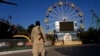 A Taliban fighter stands guard in an amusement park in Kabul, Afghanistan, Nov. 10, 2022. The Taliban have banned women from using gyms and parks in Afghanistan. The rule, which comes into force this week, is the group's latest edict cracking down on women.