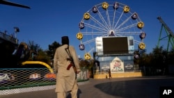 A Taliban fighter stands guard in an amusement park in Kabul, Afghanistan, Nov. 10, 2022. The Taliban have banned women from using gyms and parks in Afghanistan. The rule, which comes into force this week, is the group's latest edict cracking down on women.