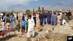 FILE - Mourners bury the body of a person killed when gunmen fired on vehicles carrying Shiite Muslims, after funeral prayers in Parachinar, the main town of Kurram district of Pakistan's northwestern Khyber Pakhtunkhwa province, Nov. 22, 2024.