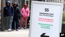 FILE - A trilingual sign directs people waiting to be led into a downtown Chicago building where an immigration court presides on Nov. 12, 2024. The White House said on Feb. 28, 2025, that President Donald Trump will designate English as the U.S.'s official language.