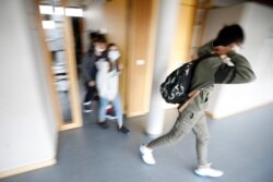 Estudiantes con mascarillas salen de su escuela en Bischheim, en las afueras de Estrasburgo, Francia, el 1 de septiembre de 2020. Millones de niños franceses comenzaron a volver a clases pese a un reciente aumento de la covid.