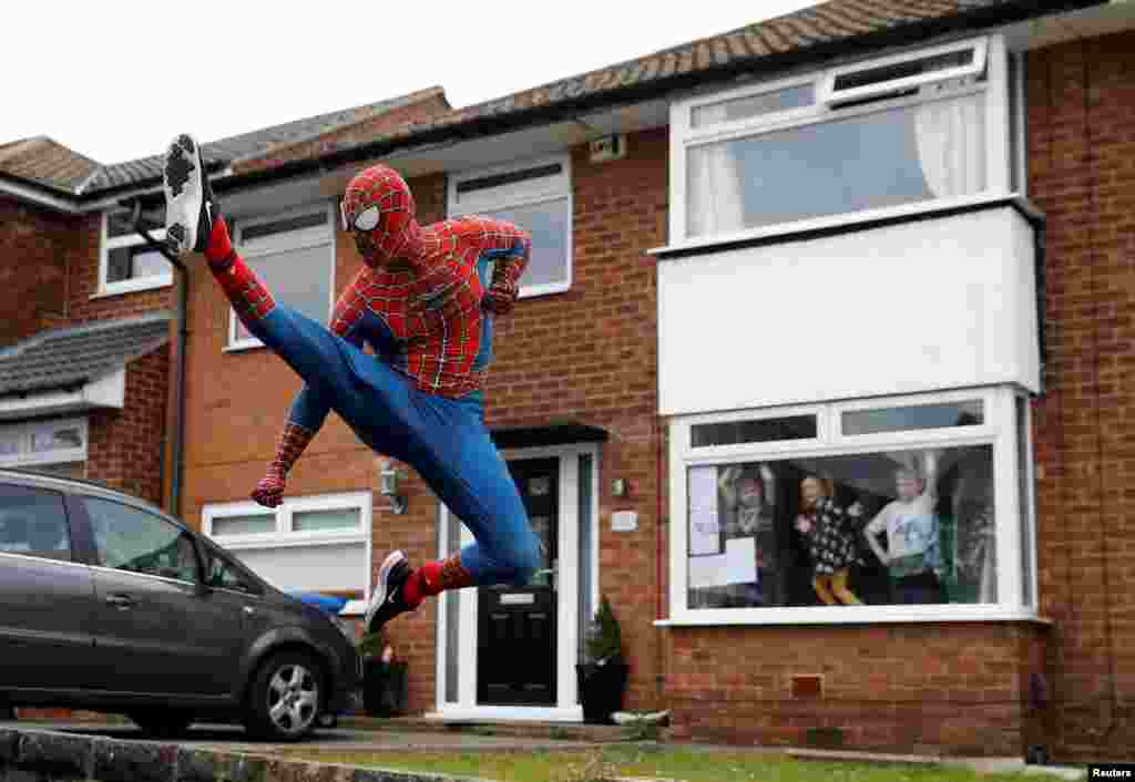 Jason Baird dressed as Spiderman exercises to cheer up local children in Stockport as the spread of the coronavirus disease (COVID-19) continues in Britain.