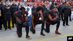 San Francisco 49ers outside linebacker Eli Harold (58), quarterback Colin Kaepernick (7) and safety Eric Reid (35) kneel during the national anthem before an NFL football game Oct. 6, 2016.