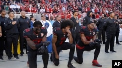 FILE - San Francisco 49ers outside linebacker Eli Harold (58), quarterback Colin Kaepernick (7) and safety Eric Reid (35) kneel during the national anthem before an NFL football game Oct. 6, 2016.