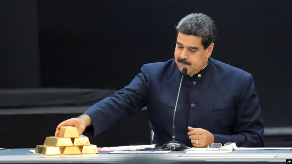 El presidente de Venezuela Nicolás Maduro toca una barra de oro mientras habla durante una reunión con sus ministros en el palacio de Miraflores en Caracas, Venezuela, el 22 de marzo del 2018. 